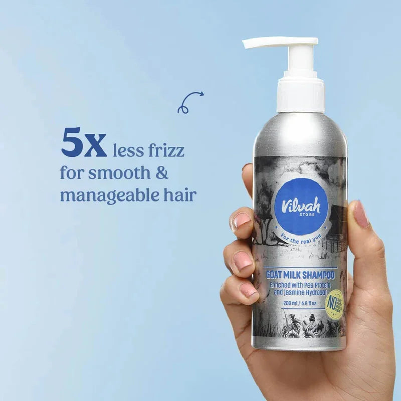 Vilvah Goat Milk Shampoo – hand holding the 200 ml bottle with less-frizz claim